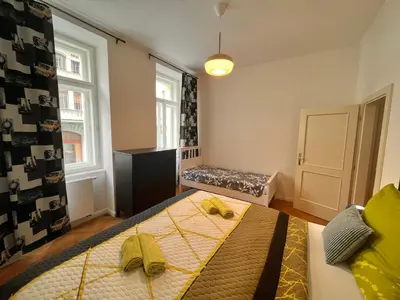 a bedroom with a bed and a bench in it at Riverbridge Apartments Prague in Prague