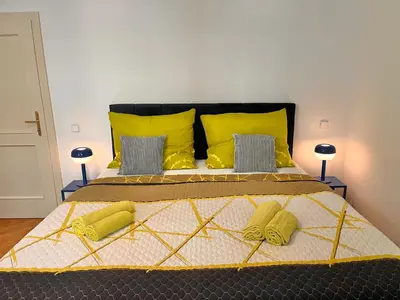 a bedroom with a large bed with yellow pillows at Riverbridge Apartments Prague in Prague