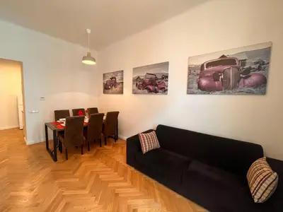 a living room with a couch and a table with chairs at Riverbridge Apartments Prague in Prague