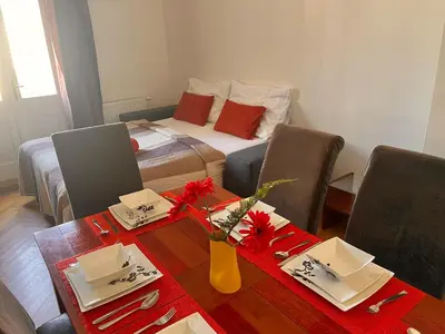 a living room with a table and a bed at Riverbridge Apartments Prague in Prague