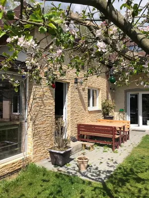 a bench in front of a house with pink flowers at Apartmán Marmeláda in Čtyřkoly