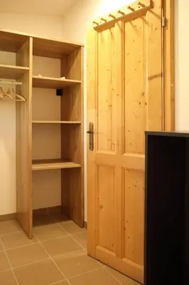 a closet with a wooden door in a room at Apartmán Marmeláda in Čtyřkoly