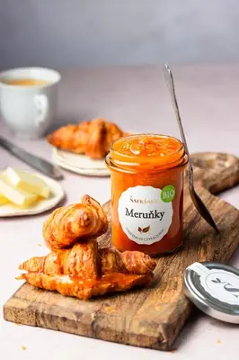 a jar of jam and some food on a cutting board at Apartmán Marmeláda in Čtyřkoly
