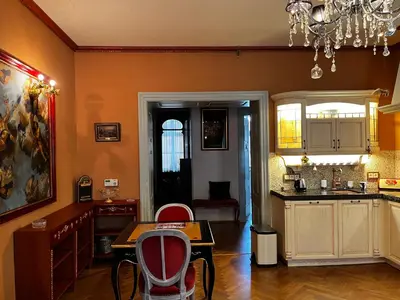 a kitchen with orange walls and a table and chairs at Le Papillon de Bohème in Prague