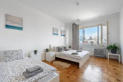 a white bedroom with a bed and a couch at Castle View Apartment Prague in Prague