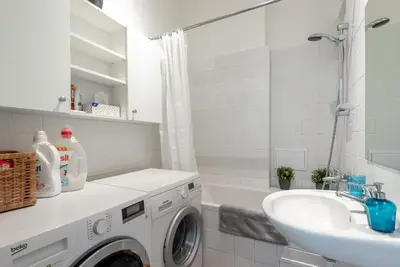 a bathroom with a washing machine and a sink at Castle View Apartment Prague in Prague
