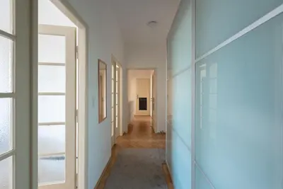 a hallway with white walls and glass doors at Castle View Apartment Prague in Prague