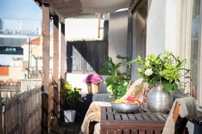 a table with a bowl of fruit and flowers on a balcony at Castle View Apartment Prague in Prague