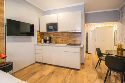 a kitchen with white cabinets and a table with chairs at Cozy studio in the main city center in Prague