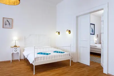 a white bedroom with a white bed and a mirror at Large 3 BDR APT in the heart of Prague in Prague