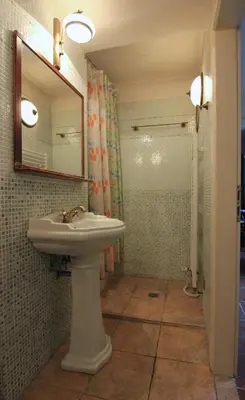 a bathroom with a sink and a mirror and a shower at 1 Bed Flat - Sleeps 3 - Courtyard - Wifi in Prague