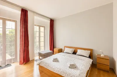 a bedroom with a bed and a large window at City Centre Garden Apartment with parking in Prague