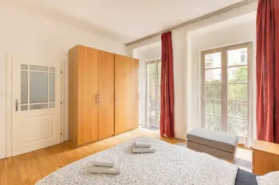 a bedroom with a bed and a large window at City Centre Garden Apartment with parking in Prague