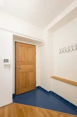 a room with a wooden door and a blue floor at City Centre Garden Apartment with parking in Prague