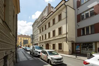 a row of cars parked on a street with buildings at City Centre Garden Apartment with parking in Prague