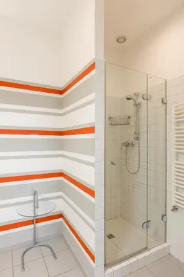 a bathroom with striped walls and a shower at City Centre Garden Apartment with parking in Prague