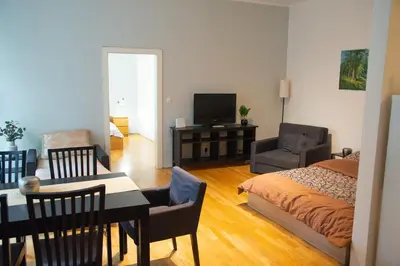 a living room with a bed and a dining room at City Centre Garden Apartment with parking in Prague