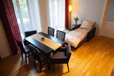 a living room with a table and chairs and a couch at City Centre Garden Apartment with parking in Prague