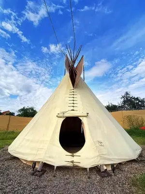a white teepee with a ladder inside of it at Teepee Camp Lounky in Chodouny