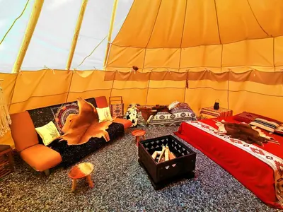 a room with a tent with a couch and a bed at Teepee Camp Lounky in Chodouny