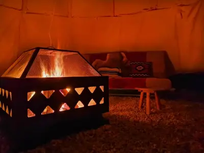 a room with a bed with a lamp in it at Teepee Camp Lounky in Chodouny