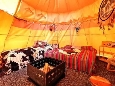 a room with a tent with a bed and a couch at Teepee Camp Lounky in Chodouny