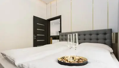 a bed with two wine glasses and a bowl on it at Luxury Apartment on Wenceslas Square in Prague