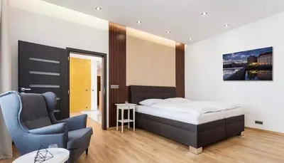 a bedroom with a bed and a chair in it at Luxury Apartment on Wenceslas Square in Prague