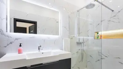 a white bathroom with a sink and a shower at Luxury Apartment on Wenceslas Square in Prague