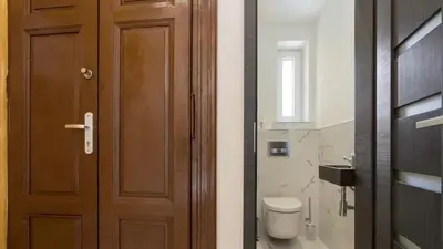 a bathroom with a wooden door and a toilet at Luxury Apartment on Wenceslas Square in Prague