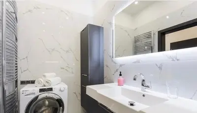 a bathroom with a washing machine and a sink at Luxury Apartment on Wenceslas Square in Prague