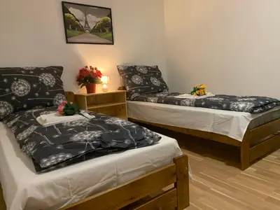 two beds sitting in a room with at Tuson Apartment in Brozany