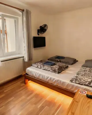 two beds in a room with pink and blue lights at Tuson Apartment in Brozany
