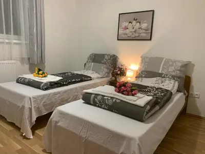 two beds in a room with flowers on them at Tuson Apartment in Brozany
