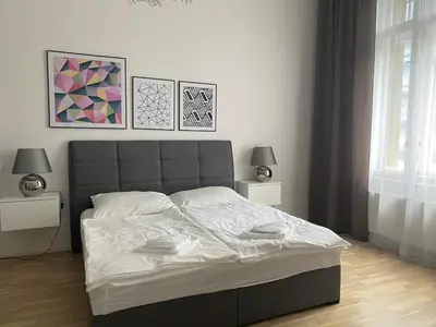 a bedroom with a bed with two night stands and two lamps at Top class apartment in old town 2 bedrooms in Prague