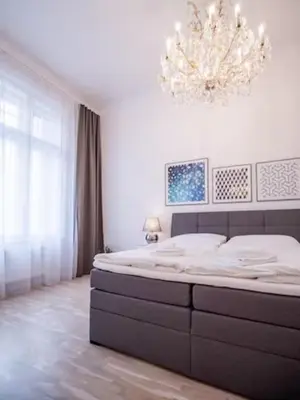 a bedroom with a large bed and a chandelier at Top class apartment in old town 2 bedrooms in Prague