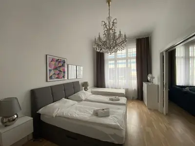 a bedroom with two beds and a chandelier at Top class apartment in old town 2 bedrooms in Prague