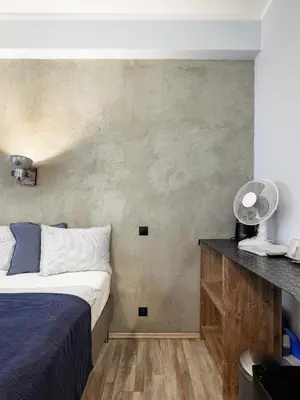 a bedroom with a bed and a concrete wall at Residence Řipská 26 in Prague