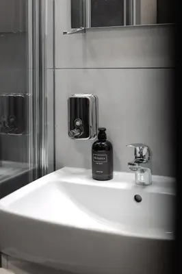 a bathroom sink with a bottle of soap on it at Residence Řipská 26 in Prague