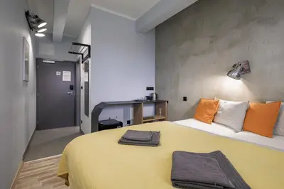 a bedroom with a large yellow bed with orange pillows at Residence Řipská 26 in Prague