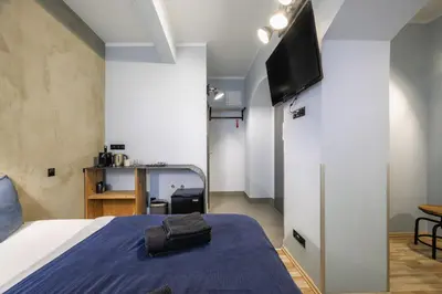 a bedroom with a bed and a tv on a wall at Residence Řipská 26 in Prague