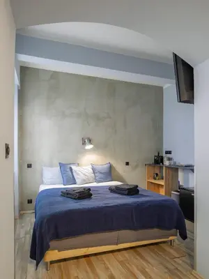 a bedroom with a large bed with a blue blanket at Residence Řipská 26 in Prague