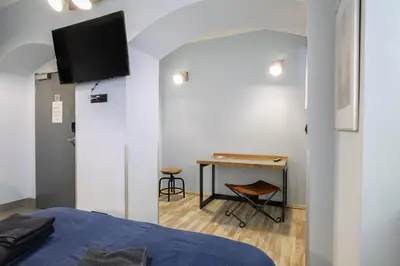 a bedroom with a bed and a desk with a television at Residence Řipská 26 in Prague