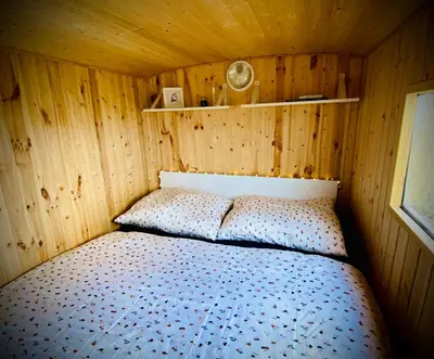 a bedroom with a bed in a wooden room at Maringotka Za Trnkou in Točník