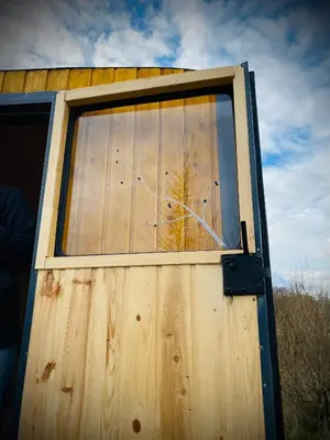 a window on the side of a wooden door at Maringotka Za Trnkou in Točník