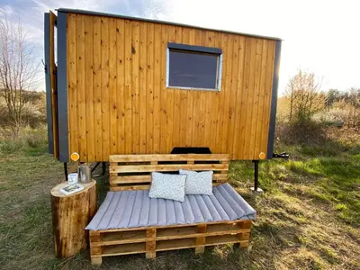 a wooden cabin with two pillows on a wooden bench at Maringotka Za Trnkou in Točník