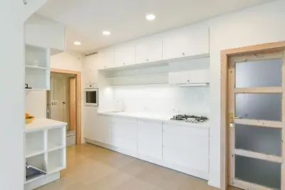 a white kitchen with white cabinets and a stove at Královské apartmá kolonáda in Poděbrady