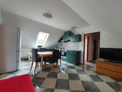 a kitchen with green cabinets and a table and chairs at Apartmán v blízkosti města Štětí in Štětí
