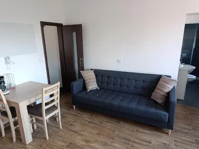 a living room with a blue couch and a table at Apartmán v blízkosti města Štětí in Štětí