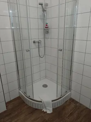 a shower with a glass door with a towel at Penzion Litohlavy 17 - Na samotě u lesa in Králŭv Dvŭr